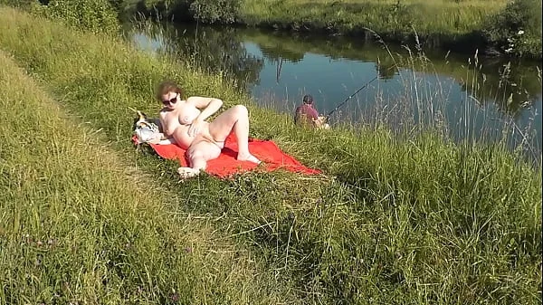 MILF sexy Frina on river bank undressed and sunbathes naked. Random man fisherman watching for her, and in the end decided to join naked woman. Wild beach. Nudist beach. Public nudity. Public exposure. Naked in public