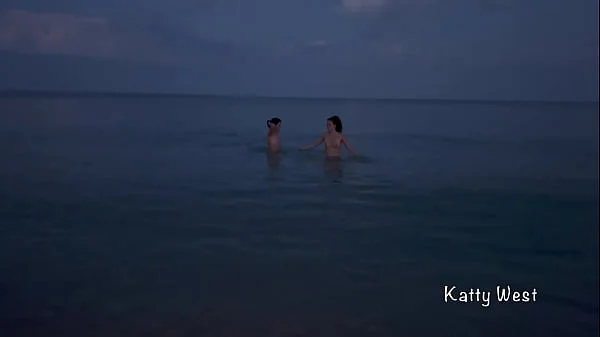 Two naked sluts play with each other in the sea on a public beach